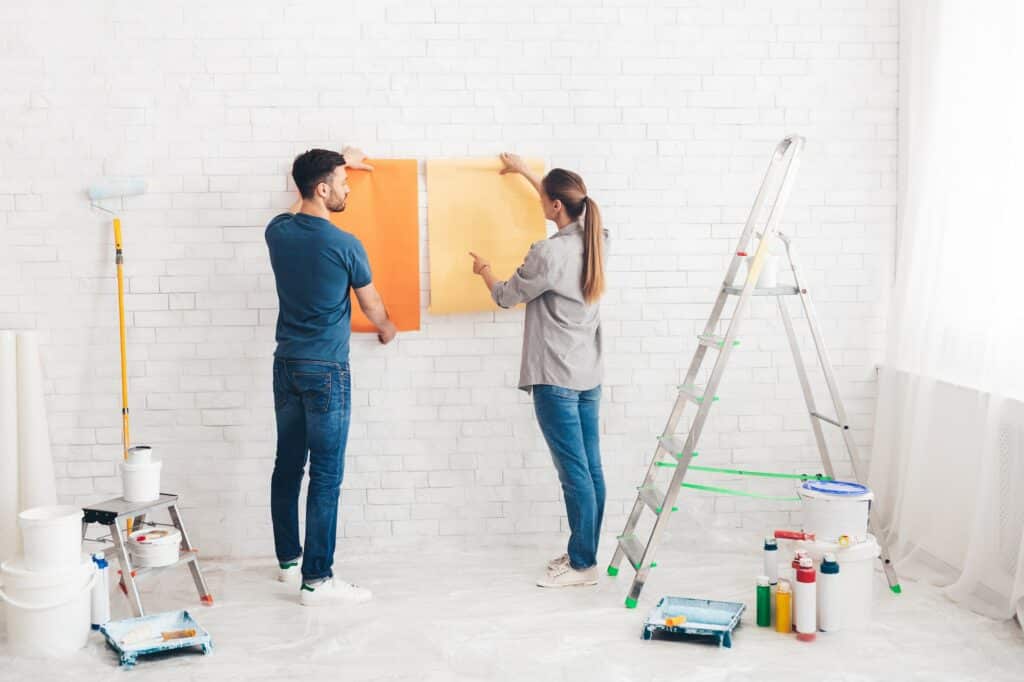 Young happy couple choosing in what color painting their new house